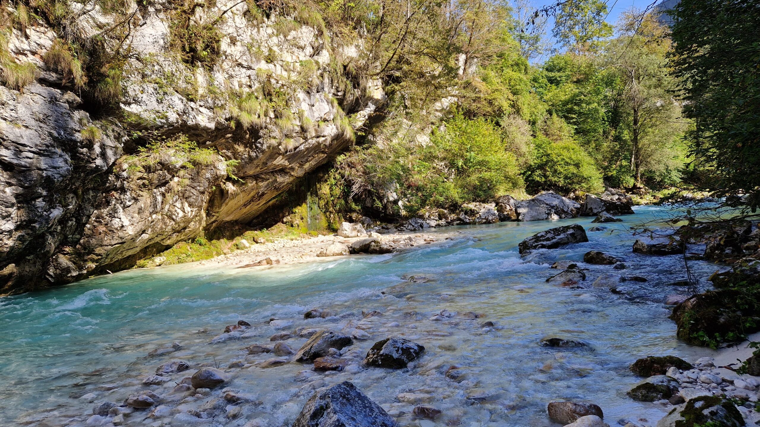 Slovenia Motorcycle Travel Guide Routes, Costs, and Tips Emerald-green Soča River flowing through valley in Slovenia with motorcycle touring road alongside