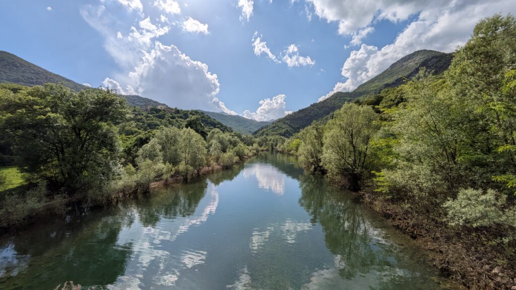 Motorcycle touring through spring European landscape with blooming wildflowers and empty mountain roads