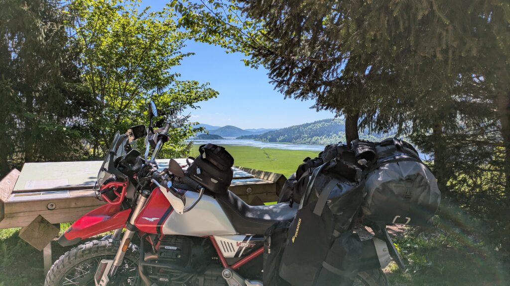 How to Find Cheap Accommodation for Motorcycle Touring Moto Guzzi V85 TT parked at Cerkniško jezero viewpoint in Slovenia — routes found through direct booking with a local host