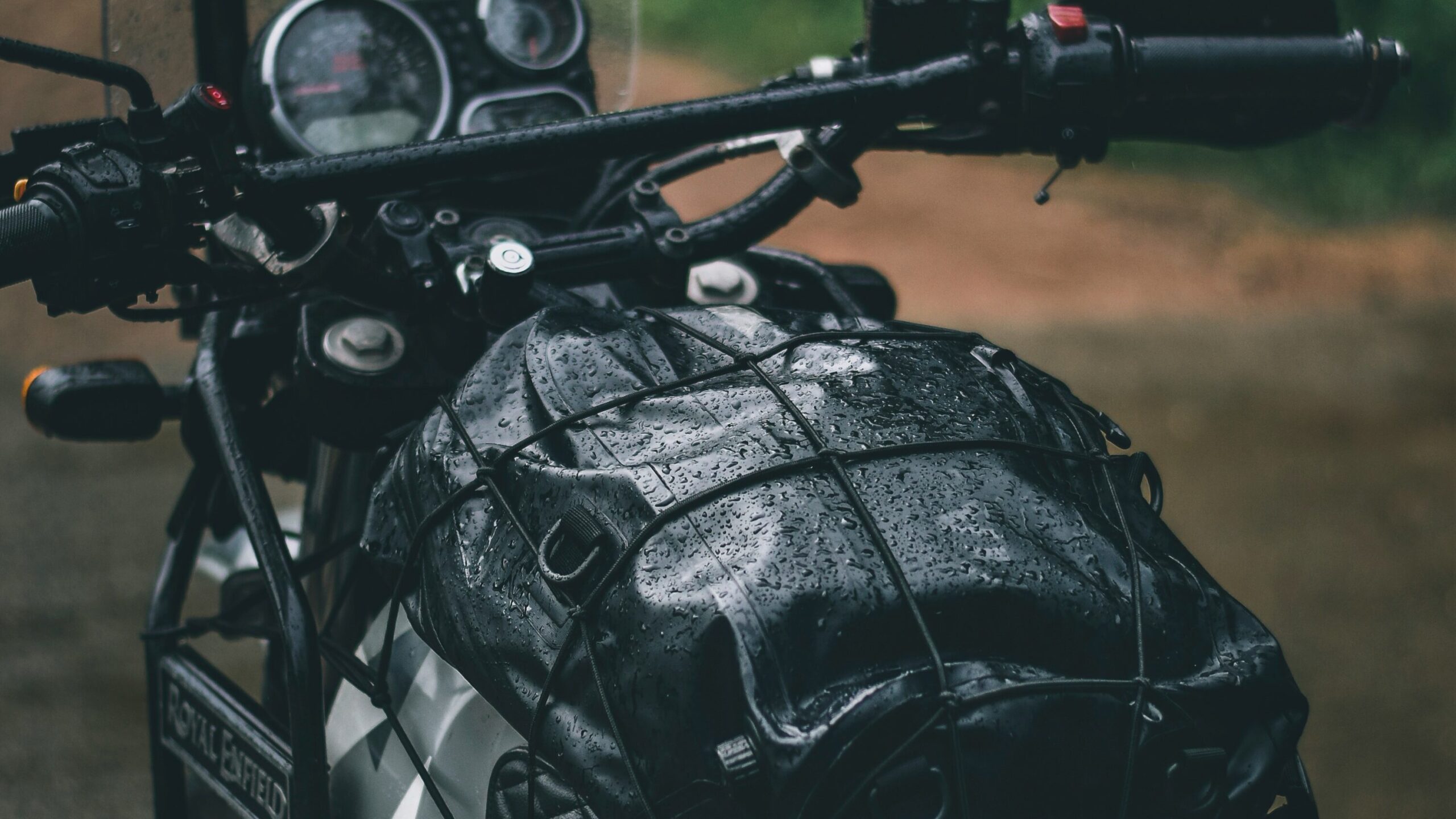 Motorcycle touring through spring mountain pass with patches of snow visible showing variable spring weather conditions in Alp