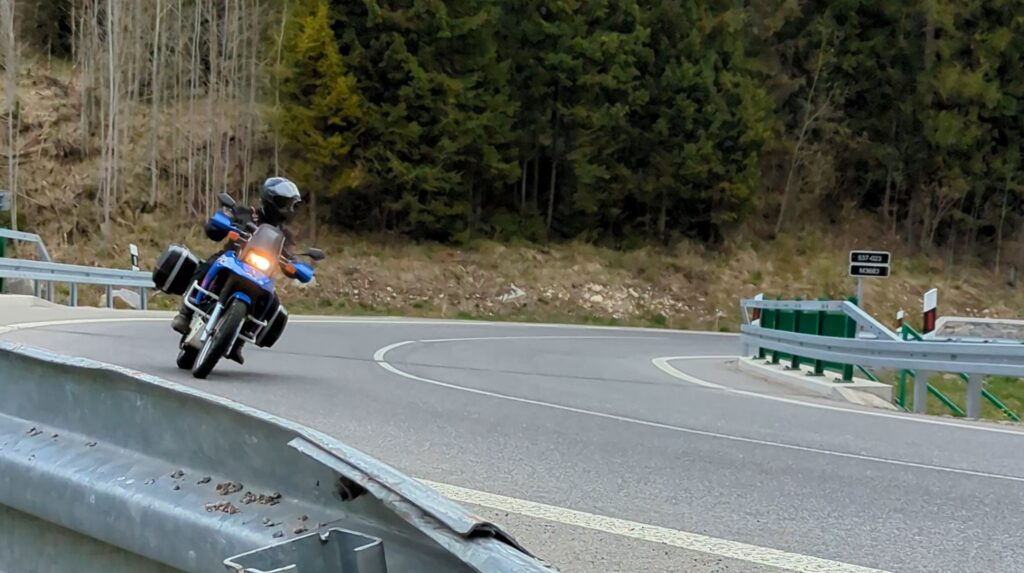 Essential Camera Gear for Motorcycle Travel Photography Suzuki DR 800 S in a hairpin corner on Road 537 Slovakia — motorcycle tripod self-portrait photography