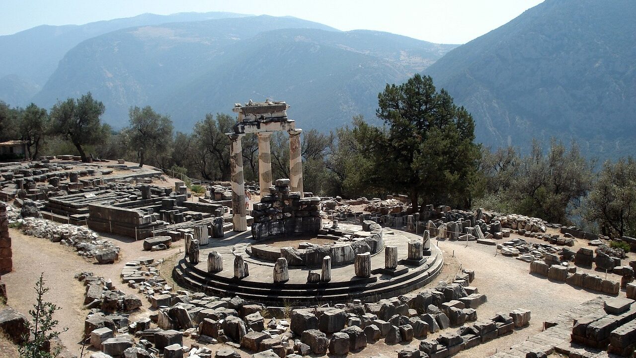 Greece Motorcycle Travel Guide: Routes and Tips Delphi archaeological site in central Greece with Mount Parnassus rising behind showing dramatic setting on greece motorcycle travel route