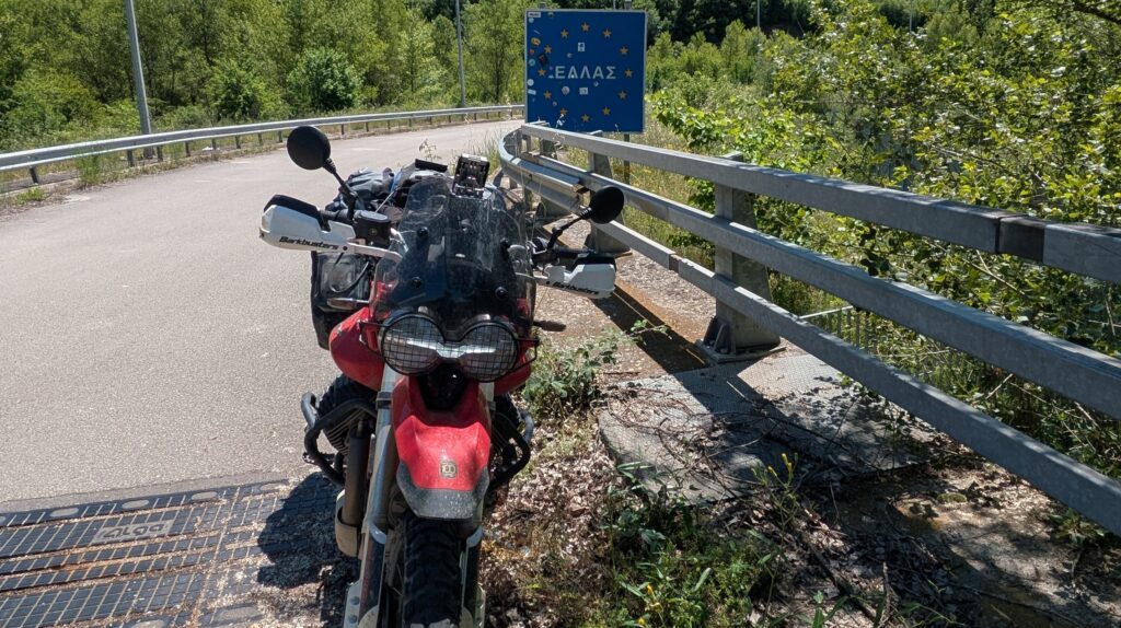 Greece Motorcycle Travel Guide: Routes and Tips Motorcycle touring on dramatic Greek coastal mountain road showing the scenery available on greece motorcycle travel beyond the beach resort experience