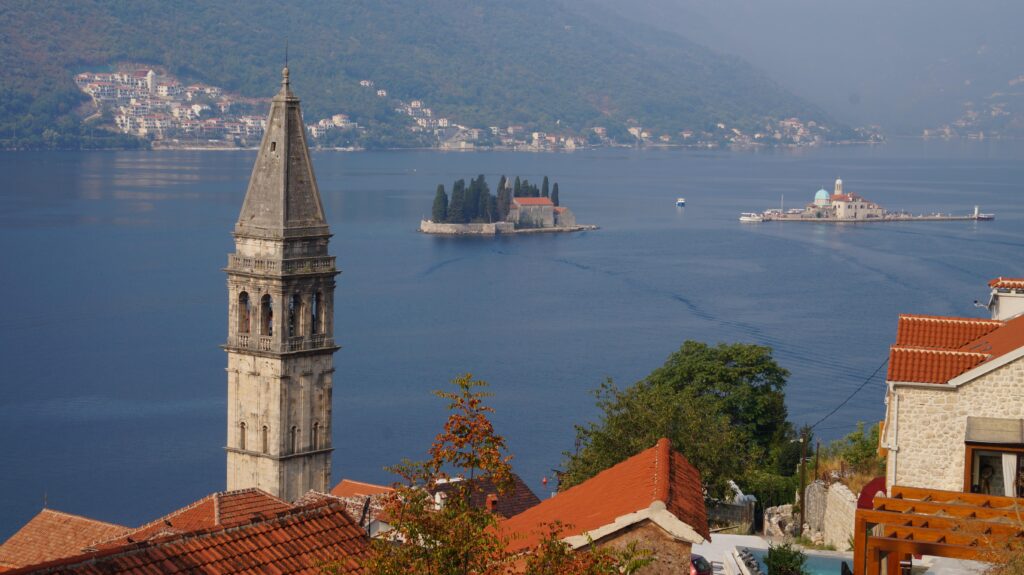 Bosnia and Montenegro Motorcycle Travel Guide Kotor old town waterfront with medieval walls and dramatic limestone mountains rising behind in Montenegro