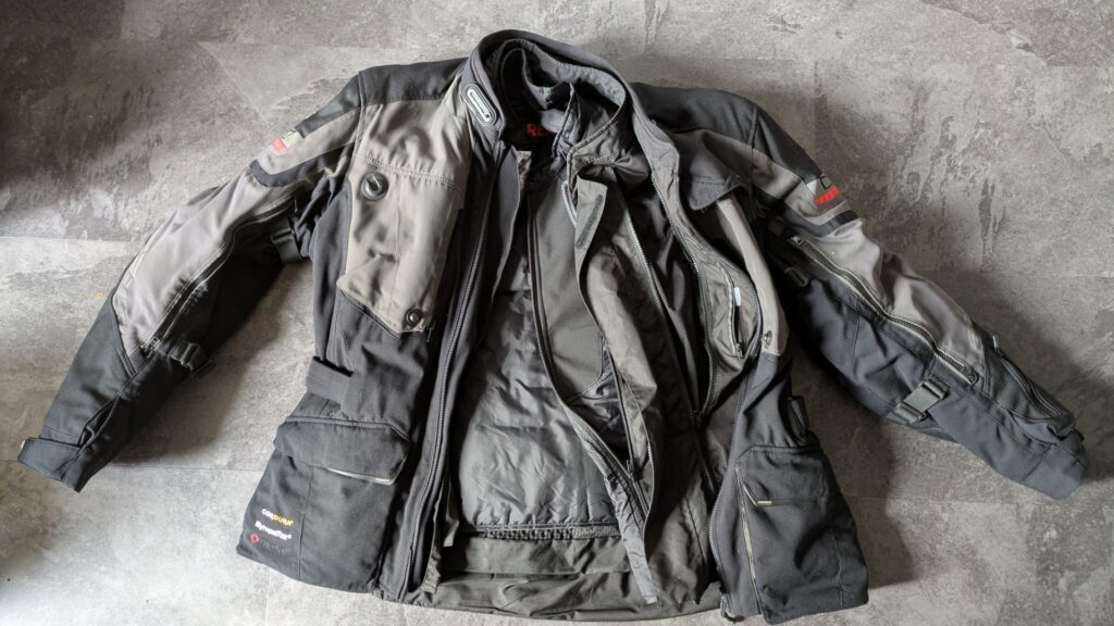 Motorcycle touring jacket with removable thermal liner and waterproof membrane showing three layer construction for variable weather