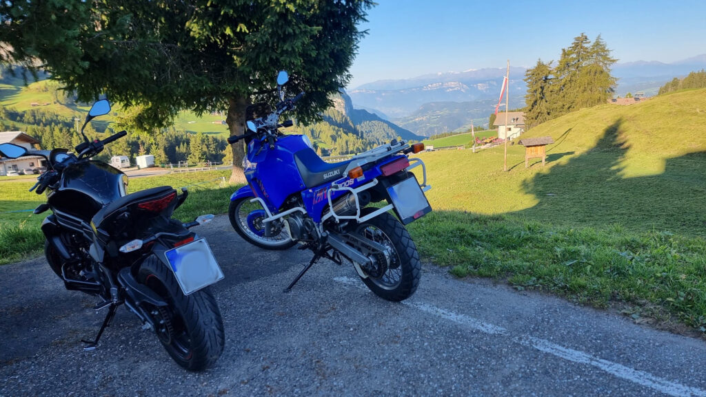 Motorcycle Weekend Trip: How to Plan a Short Tour Touring motorcycle parked outside a guesthouse at dusk on a Friday evening